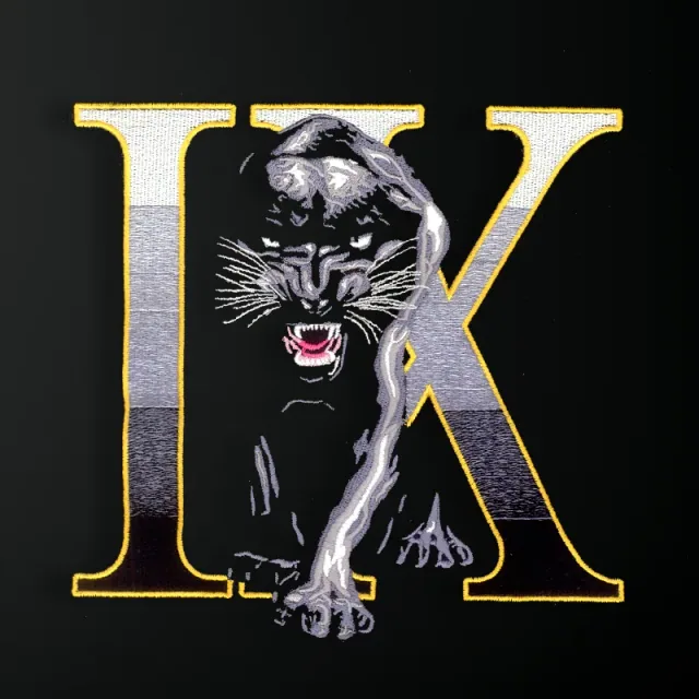 Dark big-cat embroidery combined with a UK letter monogram